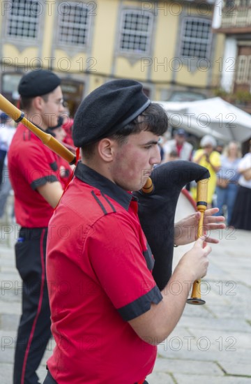 Traditional piper in band performing on city streets on May Day 2025, Guimaraes, Braga district,
