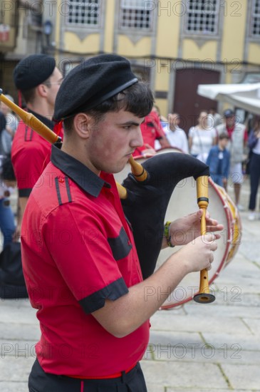 Traditional piper in band performing on city streets on May Day 2025, Guimaraes, Braga district,