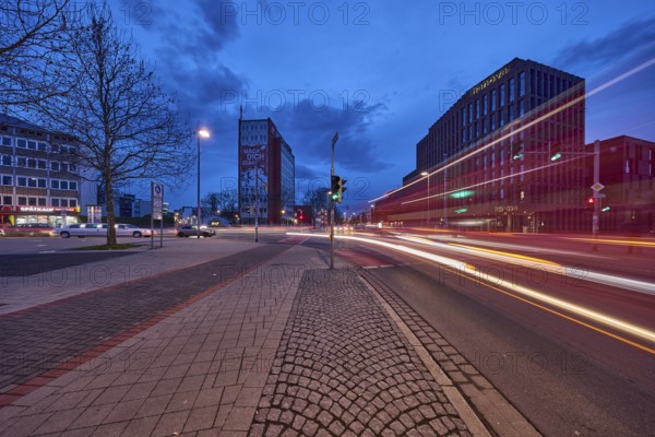 General architecture, modern building, bare wintry trees, traffic lights, pavement made of paving
