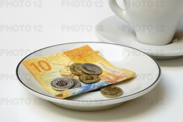 Tip, Swiss coins and Swiss franc note on plate, Switzerland, Europe