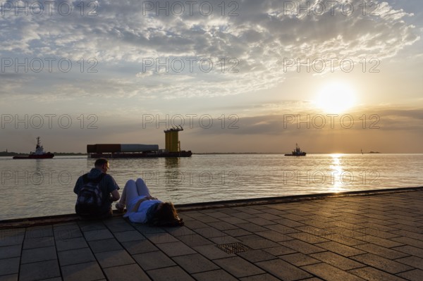 Tourists enjoying the view, sunset on the Weser, pier Seebäderkaje, pontoon, Willy-Brandt-Platz,