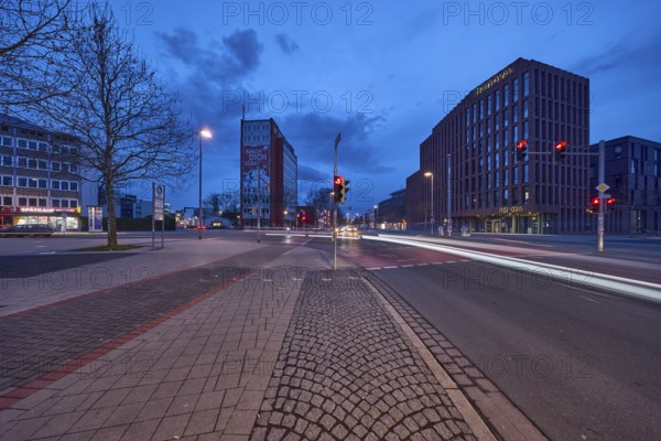General architecture, modern building, bare wintry trees, traffic lights, pavement made of paving