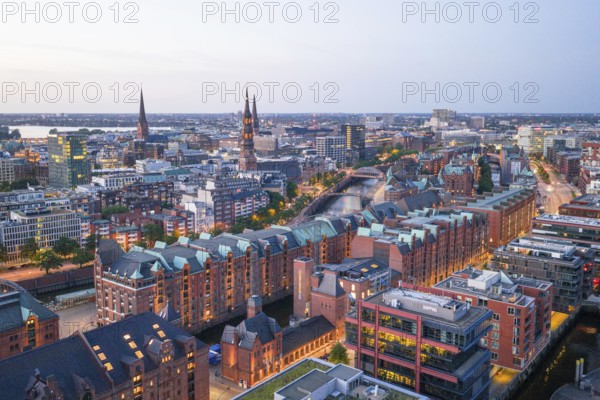 Aerial view of the Speicherstadt Hamburg at blue hour with churches and Alster in the background,