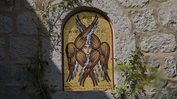 Detailed view of a mosaic with a winged saint on a stone wall, woman's monastery, Evangelismou