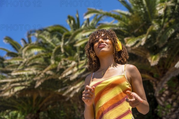 Tourist enjoying music while wearing headphones in a vibrant tropical paradise, surrounded by