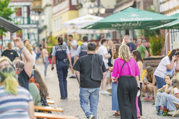Street scene with people and policemen during a summer entertainment in the city, railway station