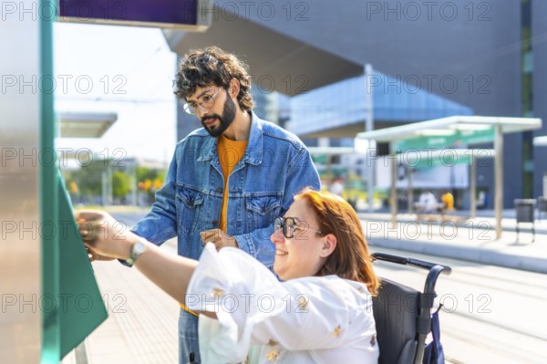 Woman in a wheelchair validating her ticket at a modern tram stop, with a friend providing
