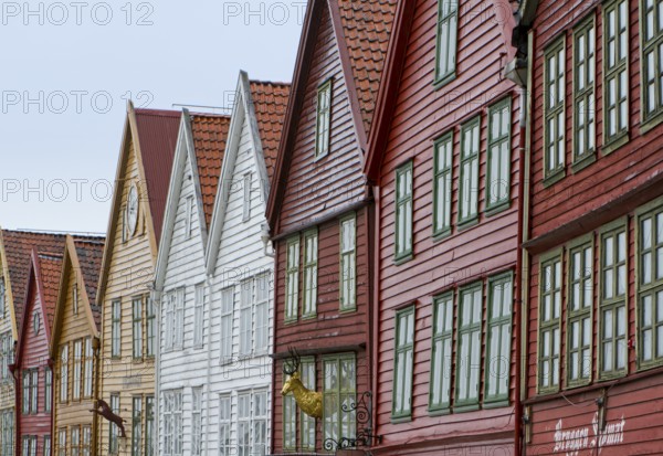 Row of colourful wooden houses with red roofs and rows of windows in Scandinavian style, Bergen,