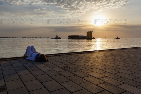 Tourist enjoying the view, sunset on the Weser, pier Seebäderkaje, pontoon, Willy-Brandt-Platz,