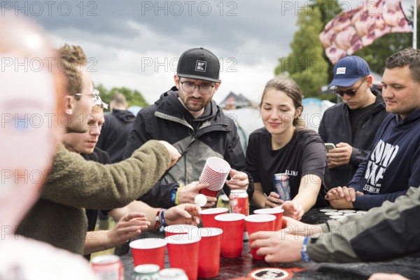 Festival visitors play a drinking game on a campsite at the Rock am Ring Festival on Saturday,
