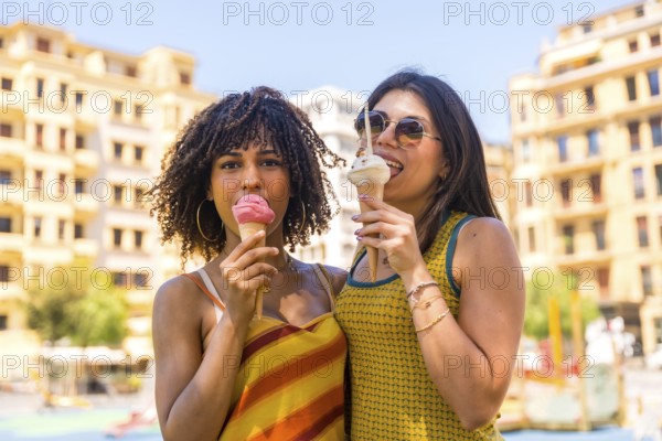 Two friends savoring delicious ice cream cones while enjoying a sunny summer day in downtown
