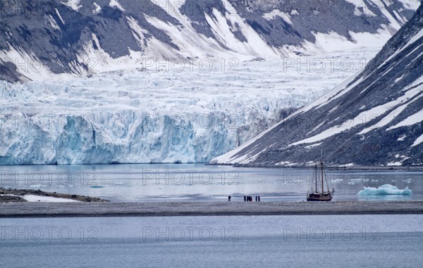 A sailboat in front of a glacier in a cold and calm arctic landscape, Magdalenenfjord with