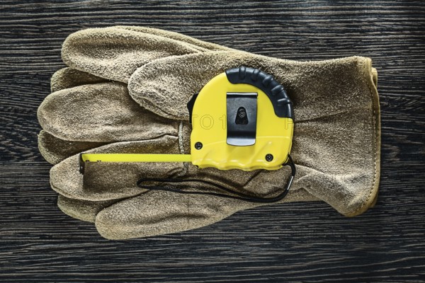 Tapeline leather protective gloves on wooden board