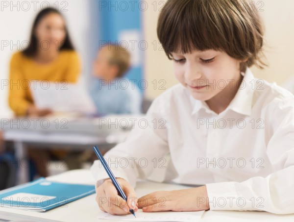 Kid writing his notebook during class