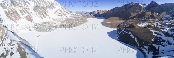 Aerial view of high altitude Tilicho Lake frozen and covered with snow in the Himalaya mountains of