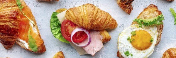 Croissant sandwich variety panorama. Different stuffed croissants, overhead flat lay shot. Rolls