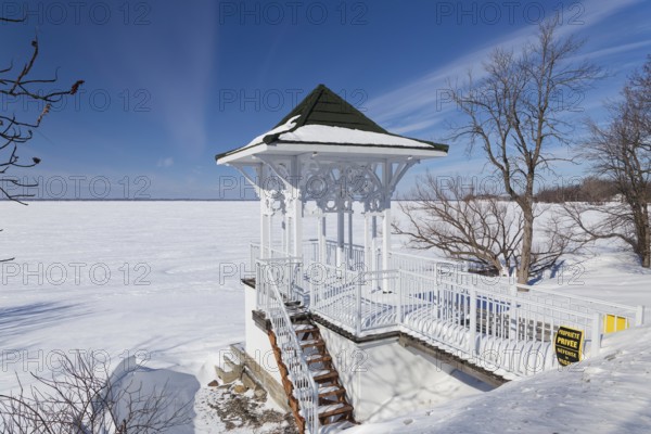 Winter, small private pavilion next to the snow and ice covered Saint Lawrence River, Lery,