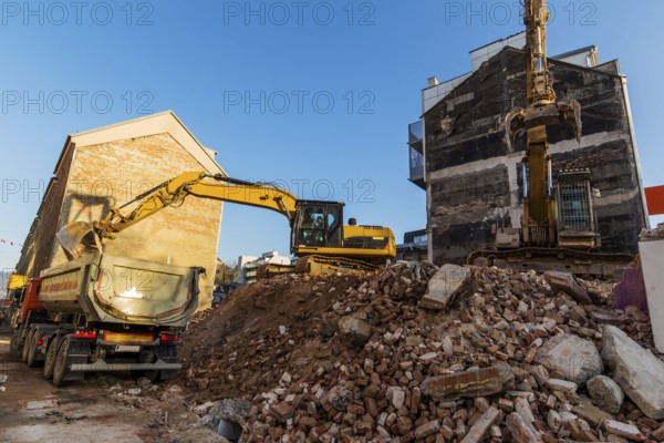 Excavators on a building site demolishing a house, creating space for new flats and living space