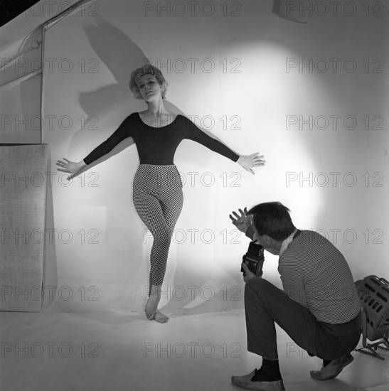 1950s photographer. A woman is posing for a photographer wearing a typical 1950s black jumper and