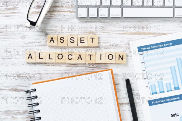 Asset allocation concept with letters on cubes. Still life of workplace with supplies. Flat lay