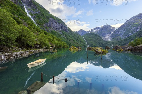 The mountain lake Bondhuswatnet. The boat is reflected in the clear water of the lake. Gorgeous