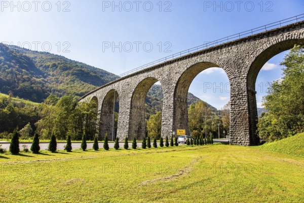 Picturesque Julian Alps. Beautiful sunny autumn day. Majestic powerful bridge over the river Idrija