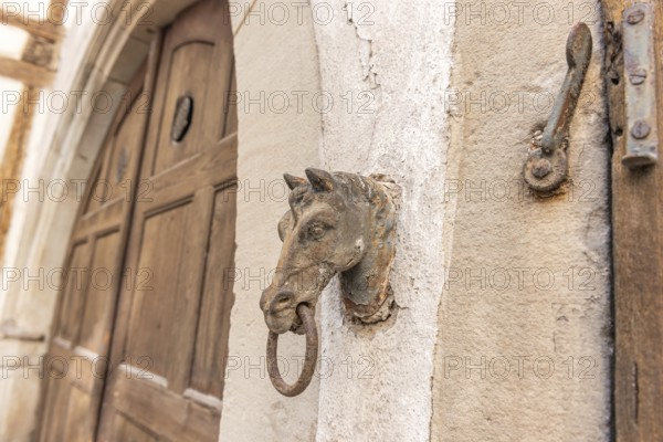 Old rusty horse's head with a ring for tying horses in a backyard. Colmar, Haut-Rhin, Collectivite