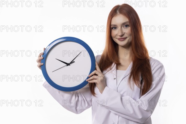 A young woman in a lab coat holds a blue clock, symbolizing effective time management and precise