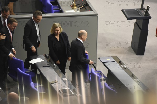 Federal Chancellor Olaf Scholz (SPD) holds on to the back of his chair while some of his ministers