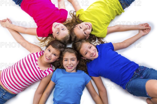 Happy kid friend girls group smiling aerial view lying on circle over white background holding