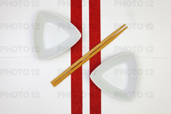 Ceramic bowls and bamboo chopsticks for sushi food with on the white wooden table.Top view. Flat
