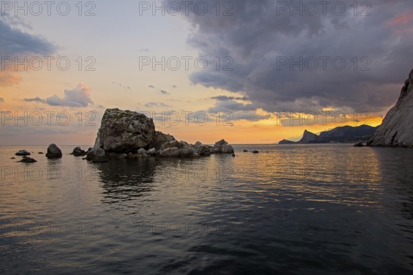 Sunset on the Black Sea coast. View from the embankment of Sudak in the direction of Novyy Svet.
