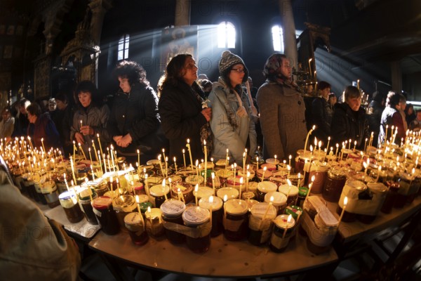 Blagoevgrad, Bulgaria - February 10, 2019: Worshippers light candles on jars with honey during a