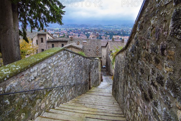 Narrow cobblestone trail leads to the top of the hill. Autumn cloudy day. Magnificent Italy. The