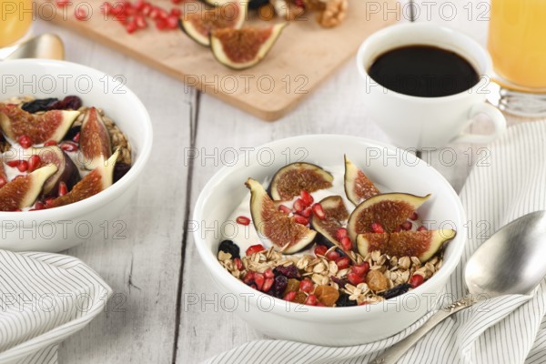 Healthy and delicious breakfast. Oatmeal muesli with Greek yogurt, fresh figs, dried fruits and
