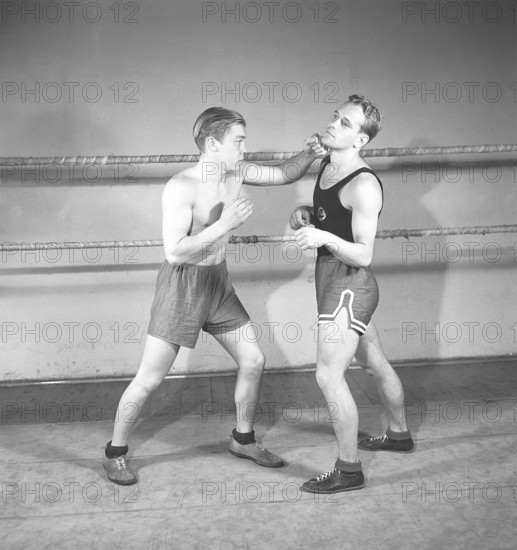Boxing in the old days. Two young boxers facing each other, dressed for boxing but lacking boxing