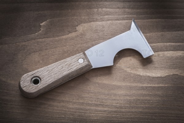 Metal putty knife on vintage wood board horizontal image