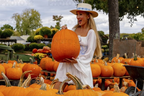 A beautiful European blonde female pics out some pumpkins and flowers for the upcoming fall