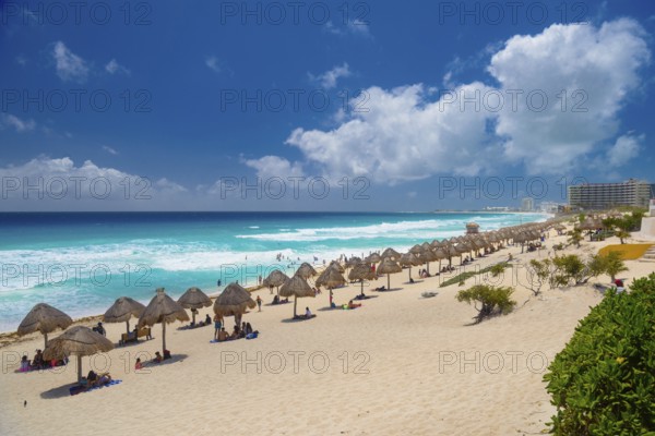 Umbrellas on a sandy beach with azure blue water on a sunny day near Cancun, Mexico, Central