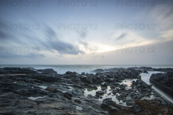 Beach, with lava rocks and vegetation, view of the sea in the evening at sunset. Landscape with