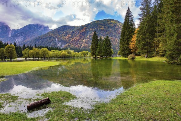 Midday in a mountain valley. Picturesque shallow lake Fuzine of glacial origin. The lake shores are
