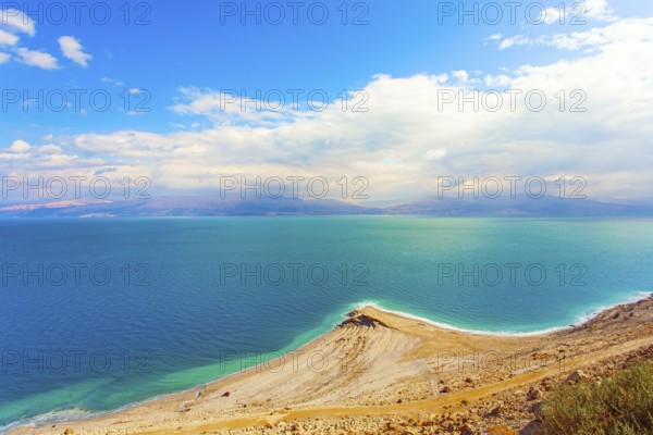 The smooth surface of the very salty sea water reflects the sky and clouds. Low winter clouds are