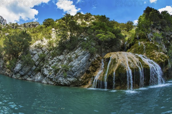 Scenic round waterfall in the side wall of the canyon Verdon. National park Merkantur, Provence,