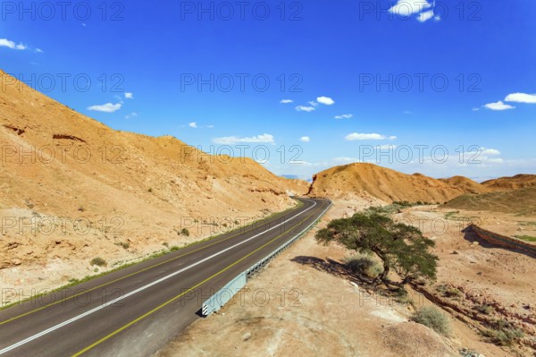 Straight as an arrow the road crosses the hills. Dry waterless hills of yelloy and beige clay.