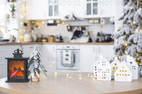 Cozy Christmas decor tiny house of small size on table of festive white modern kitchen. Gift for