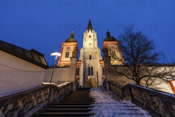 Snow on staircase, facade of the pilgrimage church, basilica of Mariazell, blue hour in the early