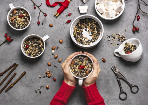 Step 2: All the cups are filled with bird seed and rosehip berries. Making feeding cups.