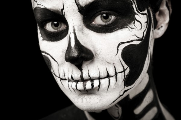Isolated on black, closeup picture, beautiful young brunette caucasian woman with scull body art,