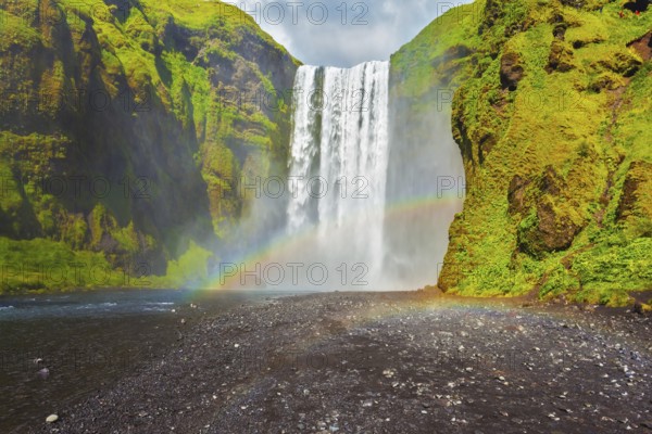 Picturesque huge rainbow appears in the water mist. The most popular waterfall in Iceland -