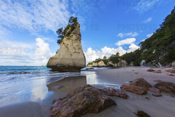 The North Island of New Zealand. Ocean low tide in Cathedral Cove at sunset. Huge boulders and